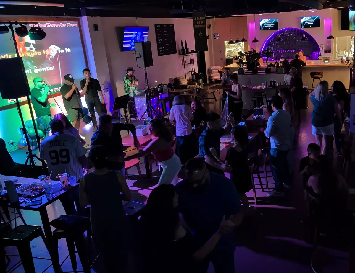 A packed karaoke night with singers on the mic, a full bar and guests eating and dancing